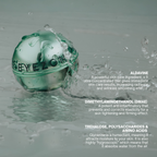 A clear round cosmetic jar filled with pale green liquid sits in shallow water with splashes around it. White text on the right lists ingredients and benefits: Aldavine, Dimethylaminoethanol (DMAE), and Trehalose, Polysaccharides & Amino Acids.