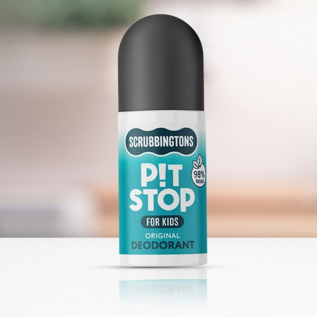 A studio shot of Scrubbingtons Pit Stop Original Deodorant for Kids. The 50ml roll-on bottle features a black cap and a teal label with a '98% Natural' seal, positioned on a white reflective surface against a soft, blurred background