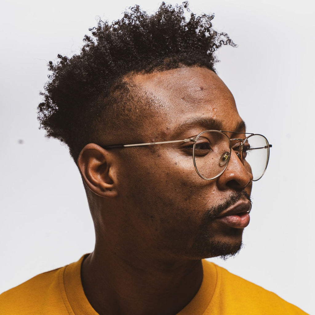 Man with coily hair, styled with Reuzel red pomade.