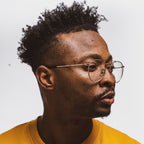 Man with coily hair, styled with Reuzel red pomade.