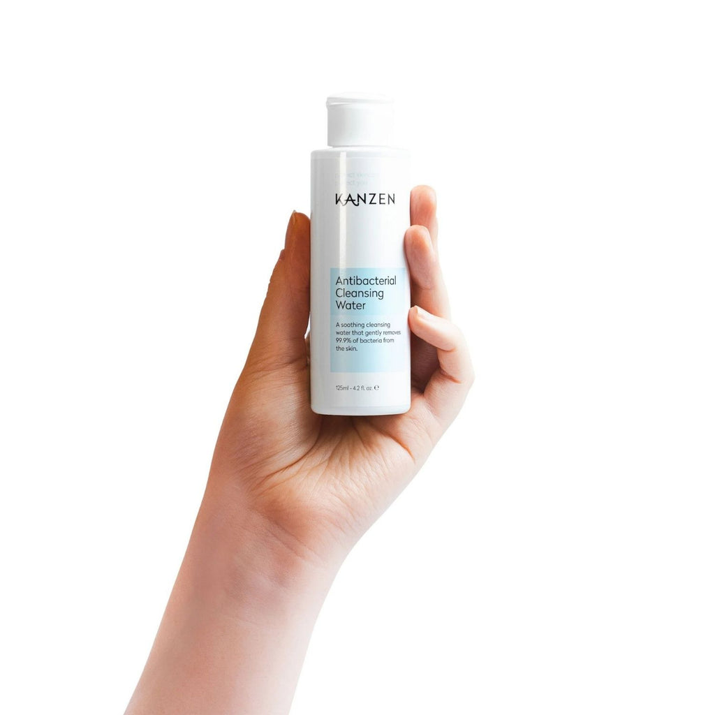Hand holding cleansing water bottle.