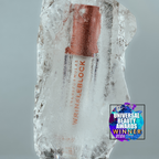 A lip gloss tube wrapped in clear ice, with a copper-toned cap and red text reading 'TRANSCUTANEOUS WRINKLEBLOCK' and 'LIP GLOSS'. A 'Universal Beauty Awards Winner 2026' badge is shown in the lower right corner against a neutral gray background.